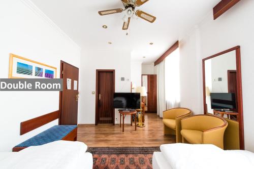 a bedroom with a living room with a bed and a tv at Ravel International in Offenbach