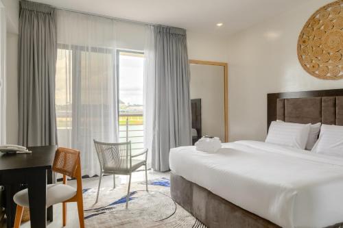 a hotel room with a bed and a desk and a window at Waterfront Villas And Wellness SPA in Warri