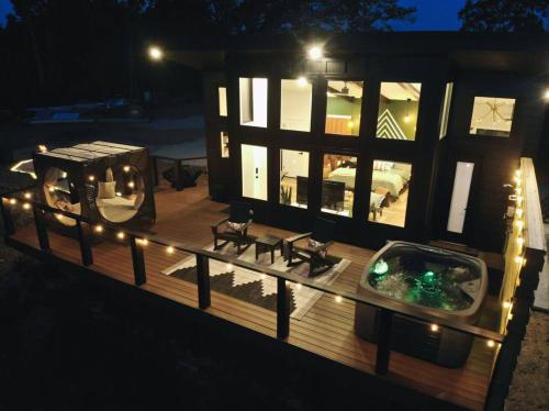 eine große Holzterrasse mit Whirlpool und Beleuchtung in der Unterkunft Private Lux Getaway Hot Tub Double Shower Cabana in Campton