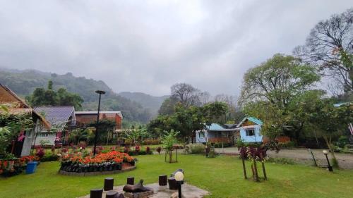 ein Friedhof in einer kleinen Stadt mit Häusern und Blumen in der Unterkunft อินทนนท์ บ้านพักเล่าจู Inthanon Laoju House in Ban Na Yang