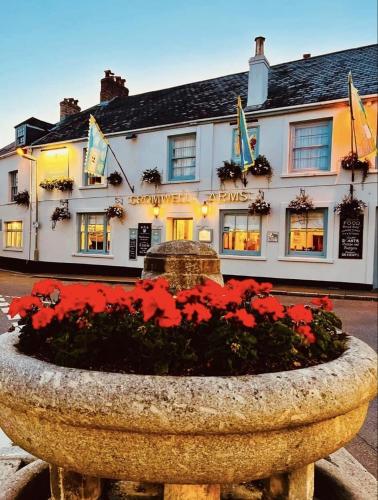 a hotel with a flower pot in front of it at Cromwell Arms in Bovey Tracey
