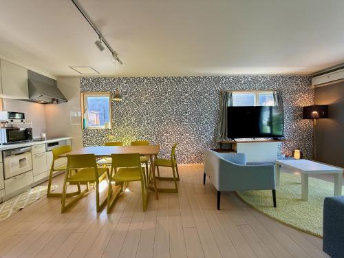 een keuken en een woonkamer met een tafel en een televisie bij The Lobs 2, Rusutsu, Yotei view, 8 mins to Rusutsu in Kimobetsu