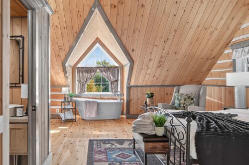 une salle de bain mansardée avec baignoire et lavabo dans l'établissement Domaine Rivière Sacacomie - Chalet Le Cardinal, à Saint-Alexis-des-Monts