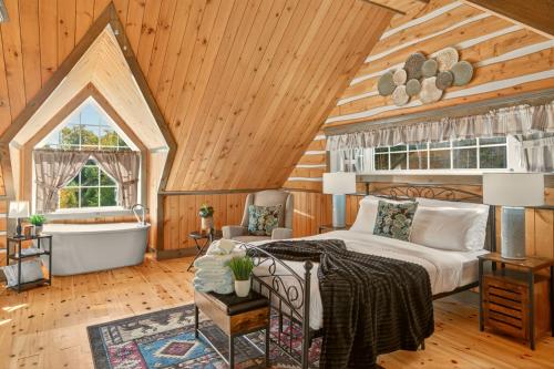 une chambre avec un lit et une baignoire dans une pièce dans l'établissement Domaine Rivière Sacacomie - Chalet Le Cardinal, à Saint-Alexis-des-Monts