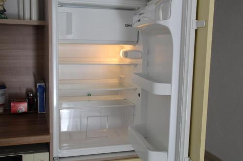 an empty refrigerator with its door open in a kitchen at Apartment FALVIG inkl. Küche in Bad Schonborn