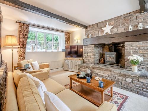 a living room with a couch and a fireplace at The Carriage House in Llanwenarth