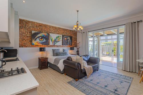 a bedroom with a bed and a couch in it at Flensborg Studios & Penthouse - Langebaan Golf Estate in Langebaan