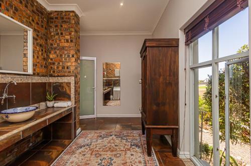 a bathroom with a sink and a large window at Flensborg Studios & Penthouse - Langebaan Golf Estate in Langebaan