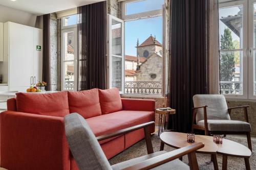 a living room with a red couch and a large window at Bracara Home By Minhos Guest in Braga