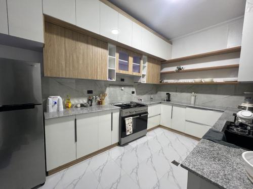 a large kitchen with white cabinets and appliances at villa Rosetta in Lege Tʼafo