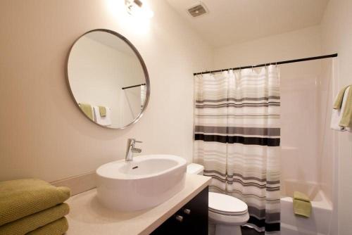 een witte badkamer met een wastafel en een spiegel bij Bridge View Loft 30 Day in Hood River