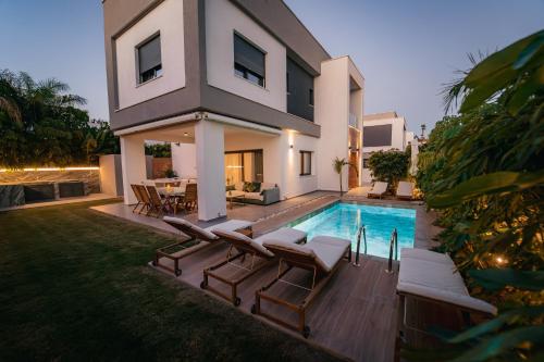 a villa with a swimming pool and a house at TG NEW Luxury Private Resort & SPA Villas - Heated Salty Swimming Pool, Outdoor Jacuzzi, Sauna, Exotic Garden in Limassol