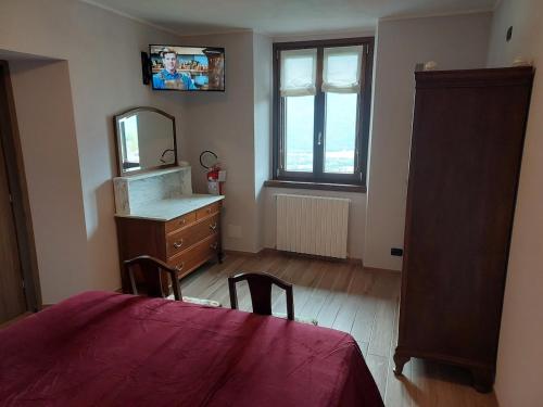 a bedroom with a dresser and a mirror and a table at La Pergola in Postalesio