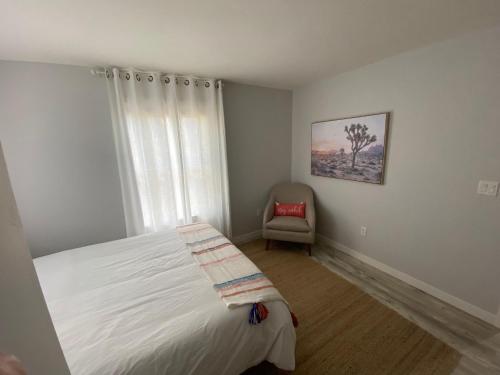 a bedroom with a bed and a chair and a window at 4th Street in Bend