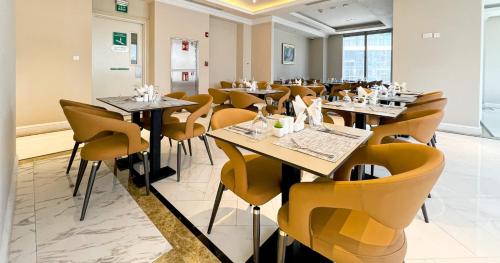 Un comedor con mesas y sillas amarillas. en Westpac Hotel & Suites - Westbay Doha, en Doha