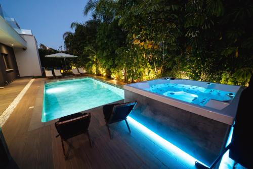 a swimming pool with a hot tub in a backyard at TG NEW Luxury Private Resort & SPA Villas - Heated Salty Swimming Pool, Outdoor Jacuzzi, Sauna, Exotic Garden in Limassol