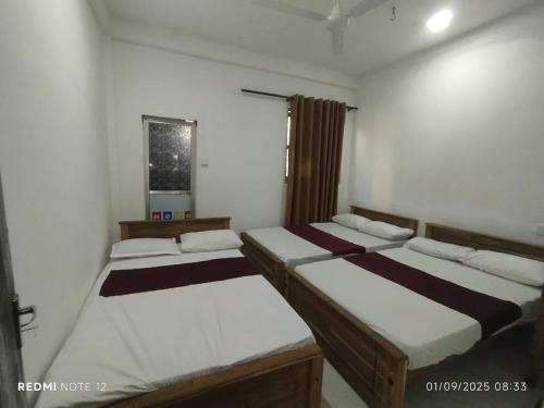 a room with three beds in it at Randuli Holiday Homes in Anuradhapura