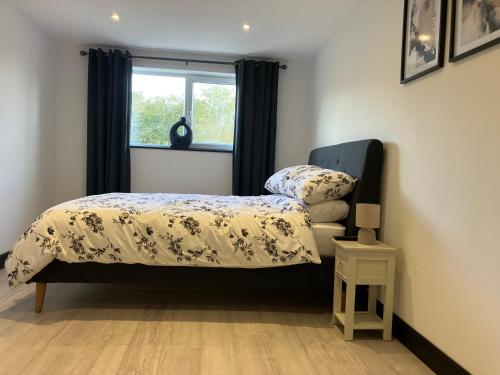a bedroom with a bed and a window at Coach house in Llantwit Fardre