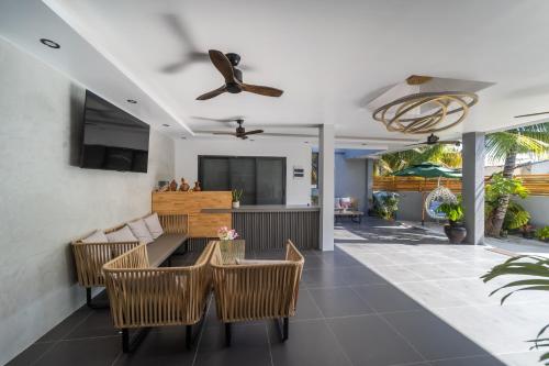 a living room with a table and chairs and a ceiling fan at Kirulhiya Omadhoo - Live the Island Dream in Omadhoo
