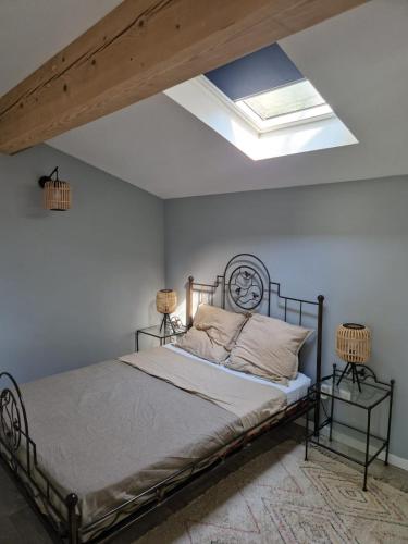 a bedroom with a bed and a skylight at Cottage with large garden in Rieumajou