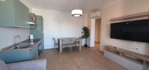 a kitchen with a table and a large television on the wall at Casa Tintoretto The Charm of Venice in 15 minutes! in Venice