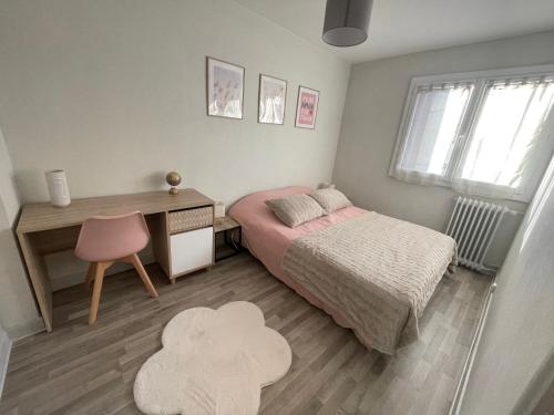 a bedroom with a bed and a desk and a chair at Appartement à 2 pas du centre, 2 chambres, parking in Aurillac