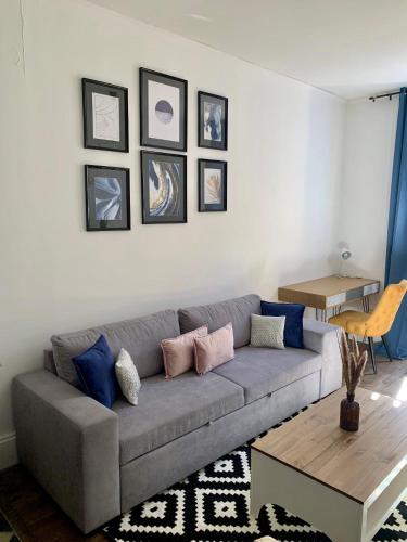 un salon avec un canapé gris et une table dans l'établissement Le cosy Flachet, à Villeurbanne