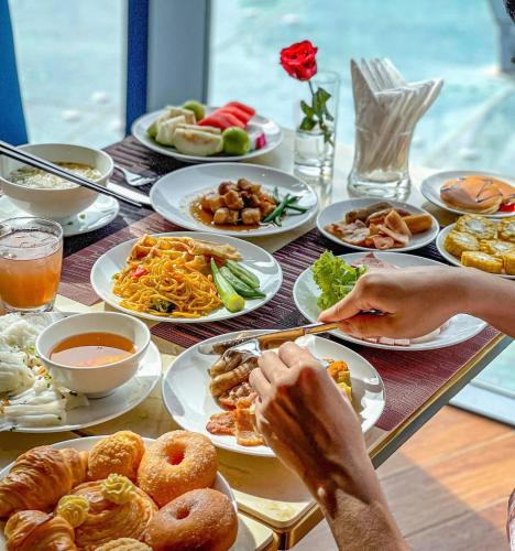 un tavolo pieno di piatti di cibo su un tavolo di INFINITY OCEAN PALACE PANORAMA Nha Trang Center a Nha Trang