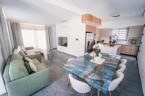 a living room with a couch and a dining table at TG NEW Luxury Private Resort & SPA Villas - Heated Salty Swimming Pool, Outdoor Jacuzzi, Sauna, Exotic Garden in Limassol