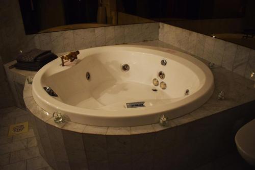 a large white tub in a bathroom with a sink at Åsele Wärdshus in Åsele