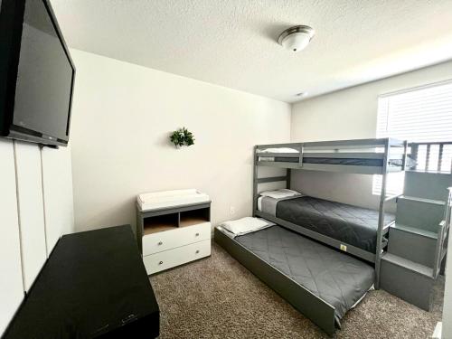 a bedroom with two bunk beds and a flat screen tv at Entire Brand New Modern Lake House Family Fun in Auburndale