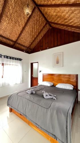 a bedroom with a large bed with a wooden headboard at Green Corner Villa in Bukit Lawang