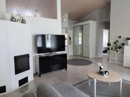 a living room with a tv and a table at Cozy detached house near the city in Rovaniemi