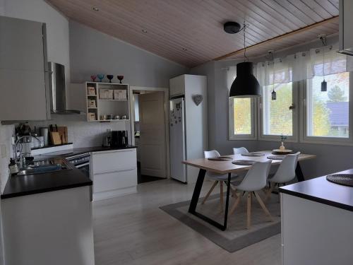 a kitchen with a table and chairs in a room at Cozy detached house near the city in Rovaniemi