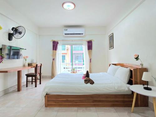 a bedroom with a bed with a teddy bear on it at You And Me Guesthouse in Cha Am