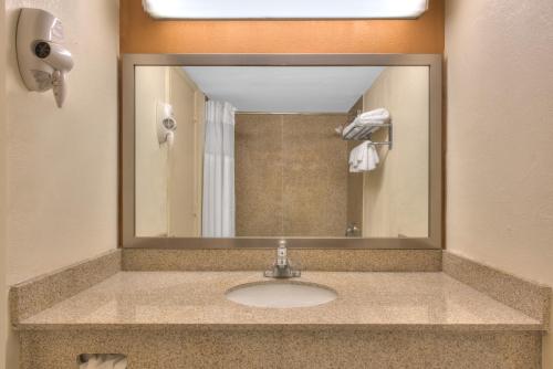 y baño con lavabo y espejo. en Express Inn Harrisburg South New Cumberland en New Cumberland