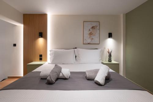 a bedroom with a large white bed with two pillows at Ground Living in Volos