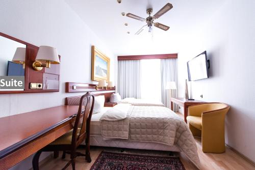 a hotel room with a bed and a desk and a desk at Ravel International in Offenbach