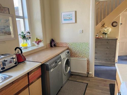 eine Küche mit Waschmaschine und Spüle in der Unterkunft 1st Class 4 Bedroom 2 Bathrooms Sleeps 9 - 11 adults in Galashiels