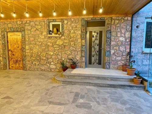 a stone house with a stone wall and a door at Nature Rock Guesthouse in Areni
