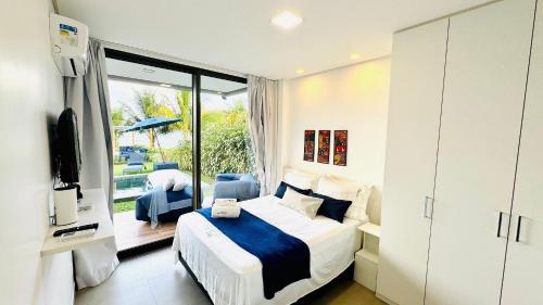 ein Schlafzimmer mit einem Bett und einer Glasschiebetür in der Unterkunft MHV Milagres - Casa OKA 37 in Passo de Camarajibe