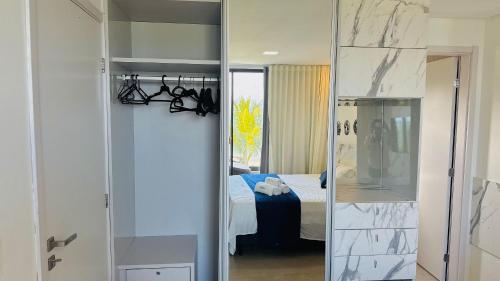 einen Spiegel in einem Zimmer mit einem Schlafzimmer in der Unterkunft MHV Milagres - Casa OKA 37 in Passo de Camarajibe