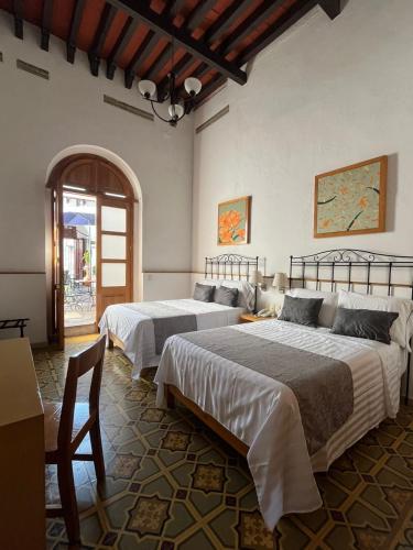 a bedroom with two beds and a table at Quinta María Hotel Boutique & Spa in Querétaro