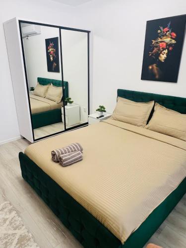 a large bed in a room with a mirror at RxM HOME CITY in Chiajna
