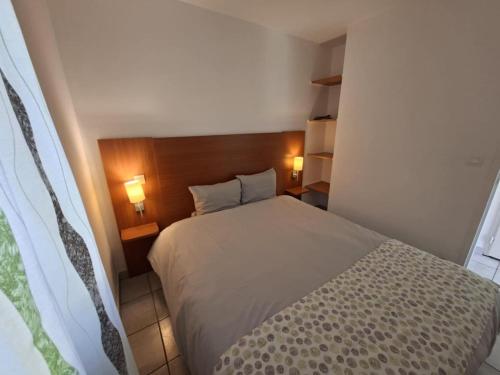 ein kleines Schlafzimmer mit einem Bett und zwei Lampen in der Unterkunft Cottage Le Vau 2, draps fournis, piscine in Chaveignes