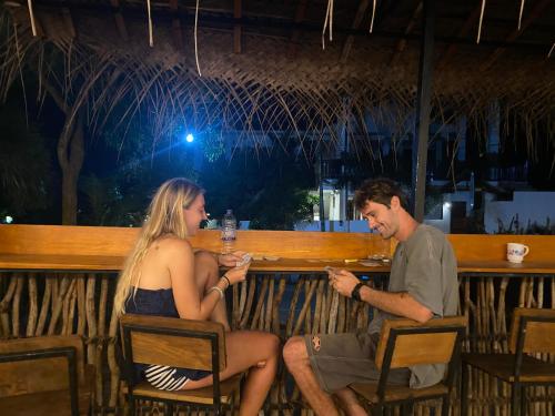 a man and a woman sitting at a bar at Wake N Flow, Hiriketiya in Hiriketiya