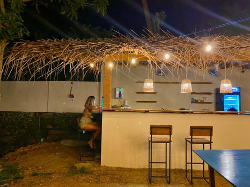 a woman sitting at a bar with three bar stools at Wake N Flow, Hiriketiya in Hiriketiya