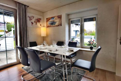 a dining room with a table and chairs and windows at Family-Friedndly Home with Large Garden &BBQ Grill in Dreieich