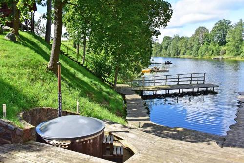 a wooden dock next to a lake with a bench at LAKE VIEW Resort - Sodyba in Skirlėnai