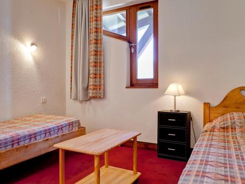 a room with two beds and a window and a table at Spacieux 3 pièces, pied des pistes, parking, balcon sud-ouest - FR-1-513-37 in La Tania